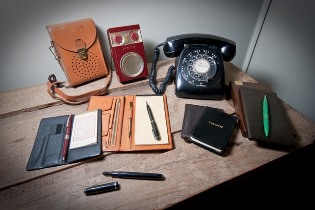 Vintage billfolds, notepads, rotary dial phone, transistor radio with case